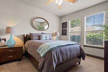 A bedroom with a large bed and two windows